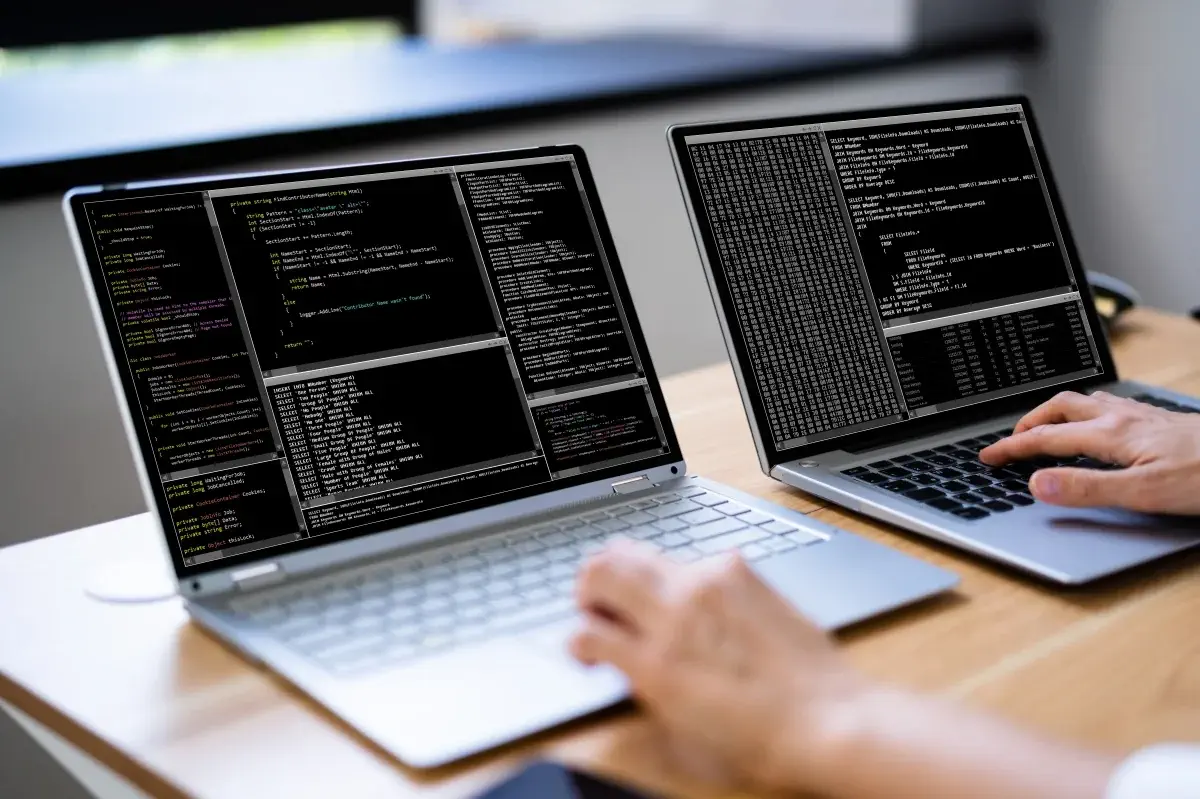 Programmer Woman Coding On Multiple Computer Screens